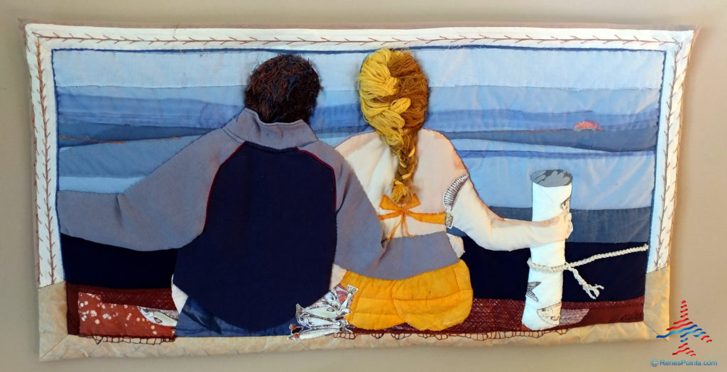 a back of a man and woman sitting on a quilt