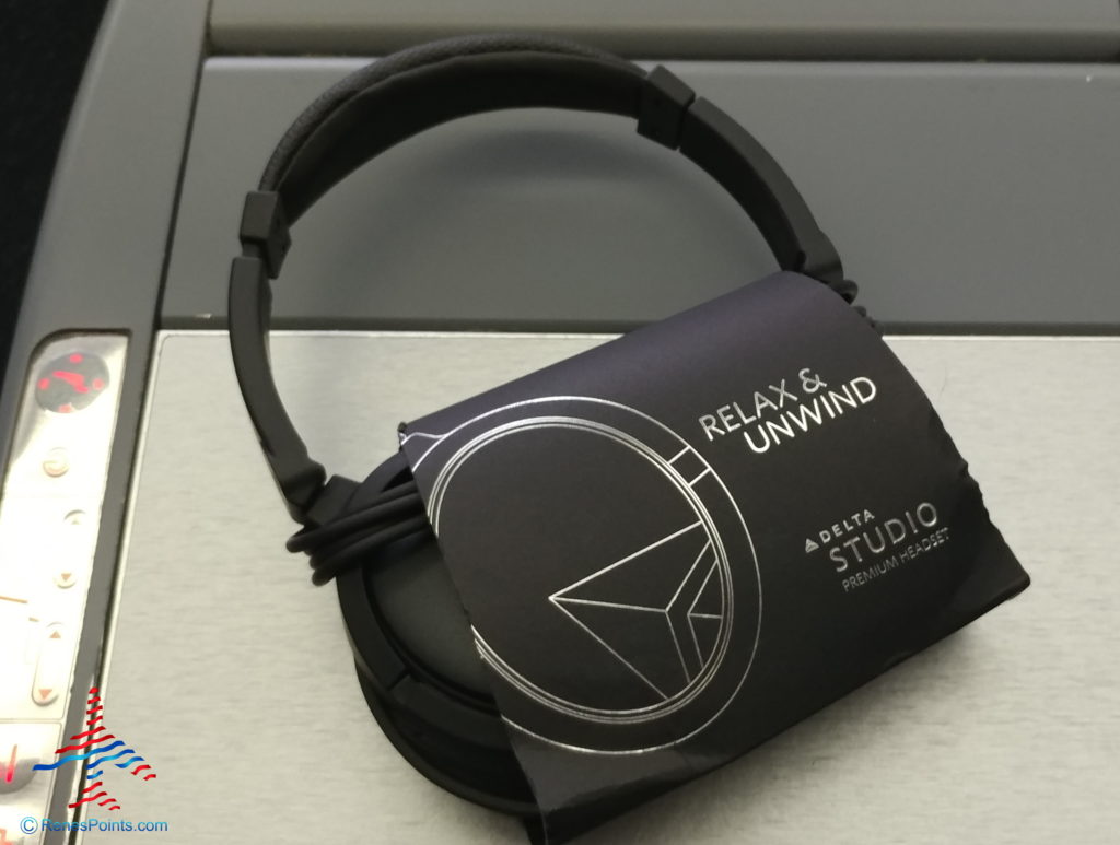 a black headphones with a package on top of a gray surface