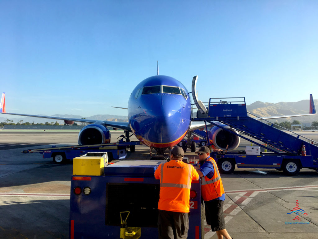 Ramp workers visit in front of a Southwest 737 parked in front of a gate at Hollywood Burbank Airport / Bob Hope Airport in Burbank, California. (BUR).