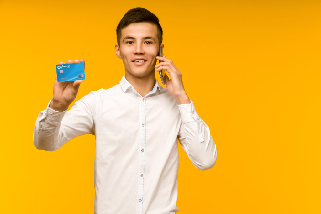 a man holding a credit card and a phone
