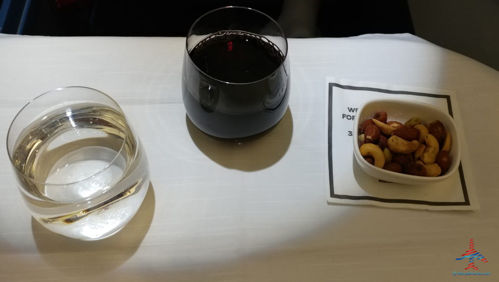 a glass of wine and nuts on a table