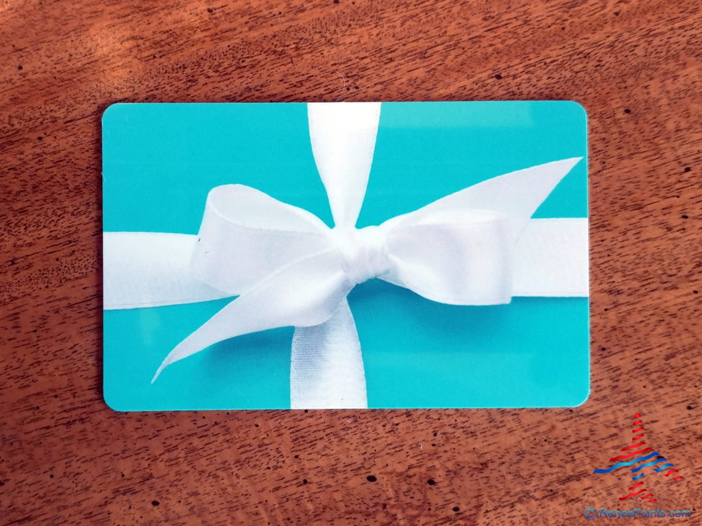 a blue gift card with a white bow