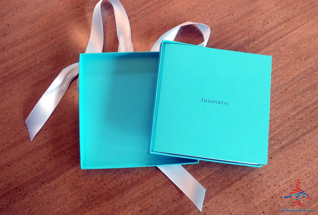 a blue box with a white ribbon on a wood surface