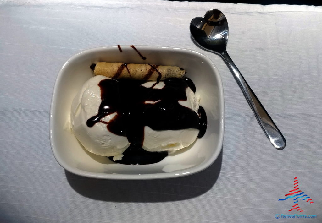 a bowl of ice cream with chocolate sauce and a spoon