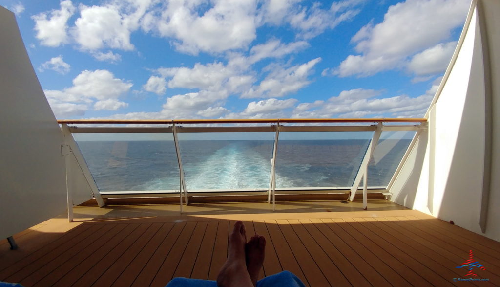 a person's feet on a deck overlooking the water