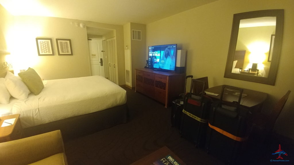 a room with a bed and a television