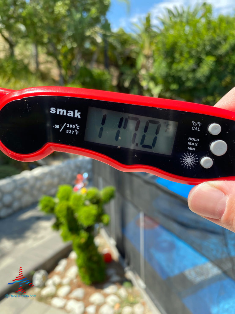 a hand holding a red and black thermometer