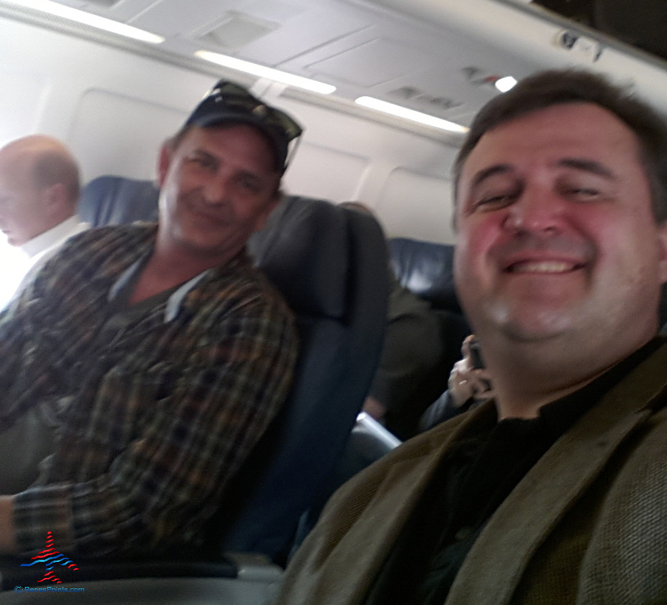 two men sitting in an airplane