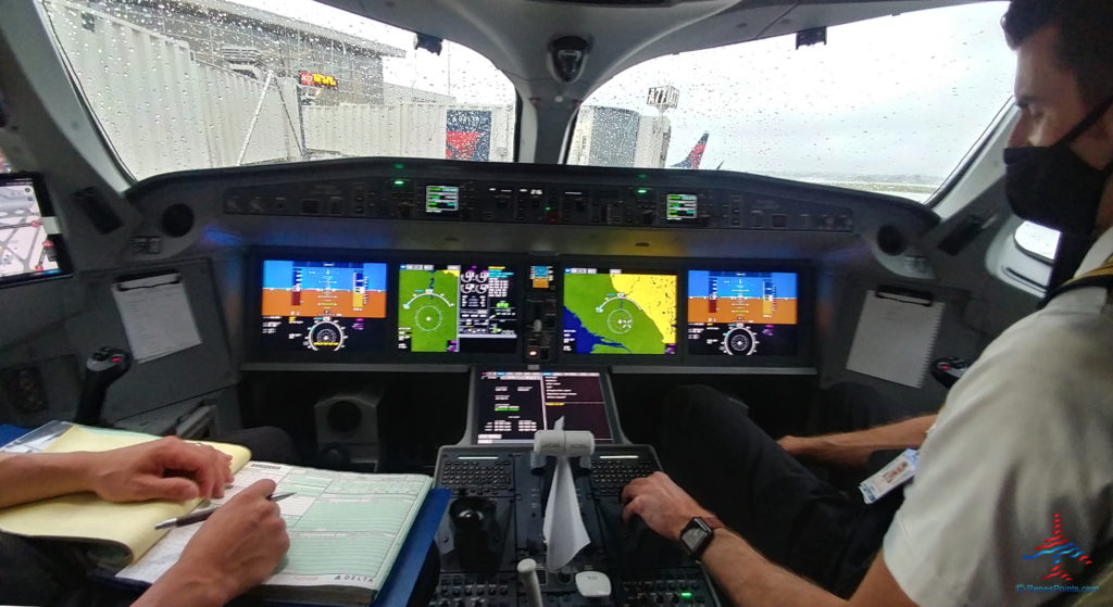a man sitting in a cockpit with a few monitors