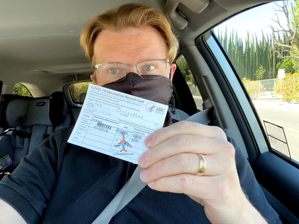 Rene's Points owner Chris Carley displays his COVID-19 vaccination card.